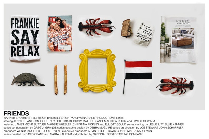 Peut inclure: Une collection d'accessoires de la s&eacute;rie t&eacute;l&eacute;vis&eacute;e "Friends" comprenant un cadre photo jaune, un t-shirt avec le texte "Frankie Say Relax", une couverture de magazine mettant en sc&egrave;ne le casting de "Baywatch", une figurine de homard, une petite figurine d'un tatou, deux b&acirc;tonnets dor&eacute;s, un morceau de pain, un morceau de papier froiss&eacute;, un petit drapeau aux couleurs noir, blanc et rouge, et un magazine avec le texte "Introducing Apothecary".