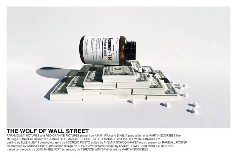 May include: A stack of cash with a bottle of Lemmon-714 Inethaqualone pills on top. The bottle is brown with a white label. The text "The Wolf of Wall Street" is printed at the bottom of the image.