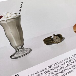 May include: A close-up of a movie poster for the film "Pulp Fiction". The poster features a milkshake, a watch, and a hamburger. The text on the poster reads "A production of a Quentin Tarantino film".