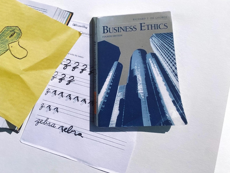 May include: A closed textbook titled "Business Ethics" by Richard T. De George, fourth edition. The cover features a blue and white illustration of skyscrapers.
