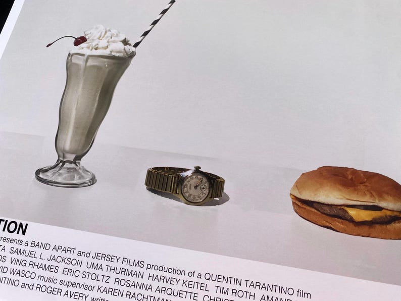 May include: A movie poster for the film "Pulp Fiction" featuring a milkshake, a hamburger, and a wristwatch. The poster text reads "Presents a Band Apart and Jersey Films production of a Quentin Tarantino film".