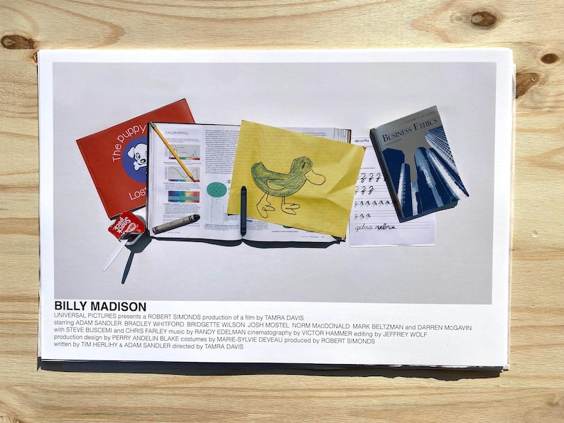 May include: A movie poster for the film "Billy Madison" starring Adam Sandler. The poster features a yellow sticky note with a drawing of a duck, a red book with the title "The Puppy", a blue book with the title "Business Ethics", and a few other school supplies.