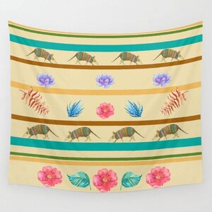 May include: A tapestry with a beige background and teal stripes. The tapestry features a repeating pattern of armadillos, flowers, and leaves. The armadillos are brown and black with yellow accents. The flowers are pink and purple. The leaves are green.