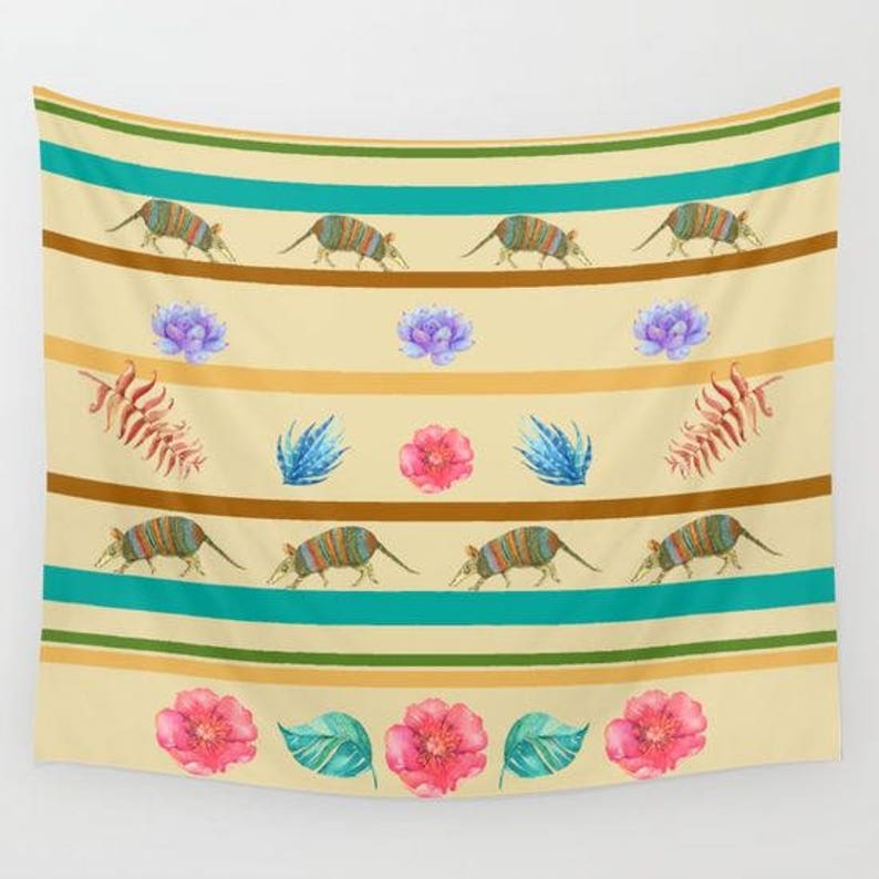 May include: A tapestry with a beige background and teal stripes. The tapestry features a repeating pattern of armadillos, flowers, and leaves. The armadillos are brown and black with yellow accents. The flowers are pink and purple. The leaves are green.