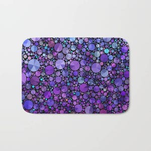 May include: Purple and blue geometric patterned bath mat with a mosaic of circles.