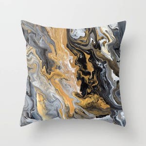 May include: A throw pillow with a black, gold, and gray abstract marble pattern.