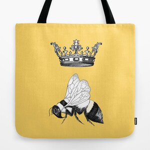 Pu&ograve; includere: Una borsa tote gialla con un'illustrazione in bianco e nero di un'ape e una corona. L'ape ha un addome a strisce e ali dettagliate. La borsa ha manici neri.