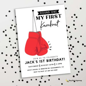 May include: White invitation card with red boxing gloves and the text "Round One My First Knockout". The card invites guests to Jack's 1st birthday party on August 12th at 3-5 PM.