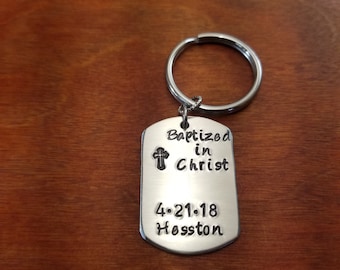 May include: Silver keychain with a cross and the text "Baptized in Christ 4-21-18 Hosston"