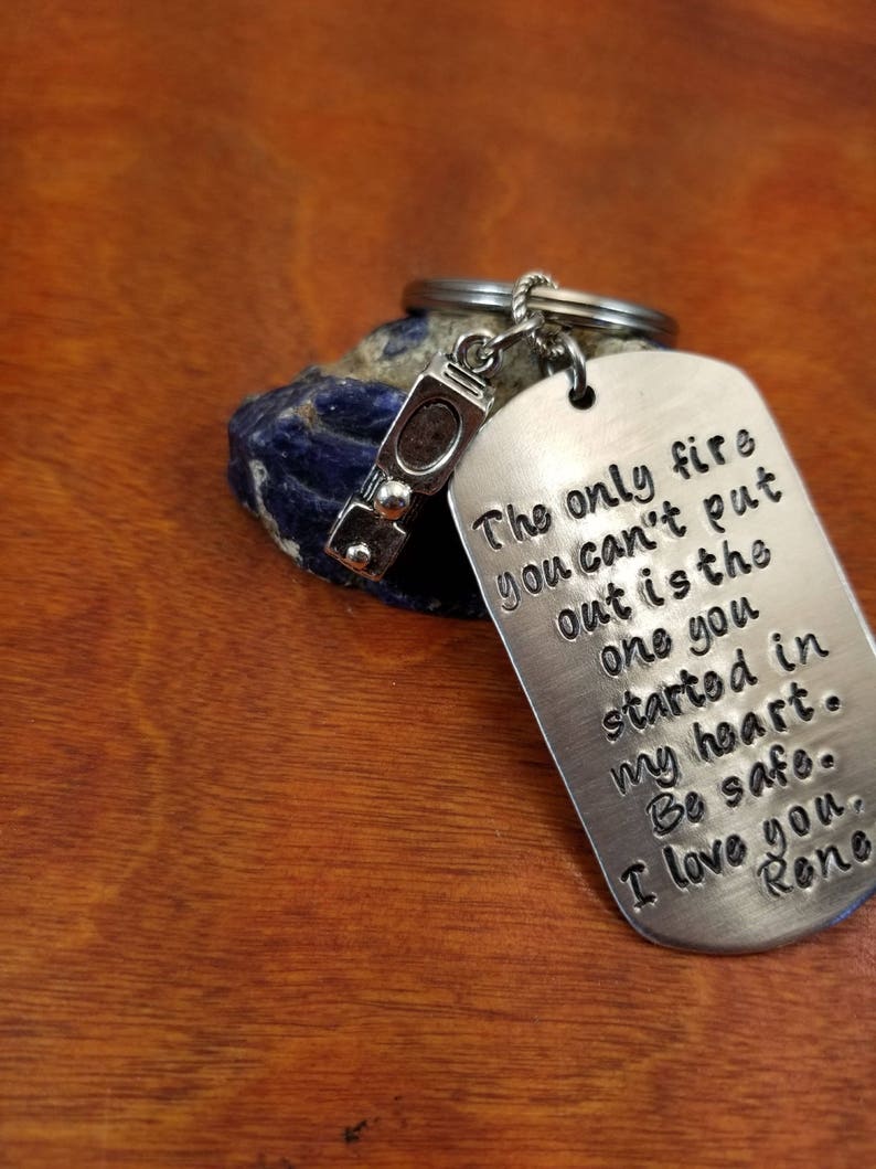 May include: Silver keychain with a small charm shaped like a fire extinguisher. The tag reads "The only fire you can't put out is the one you started in my heart. Be safe. I love you, Rone."