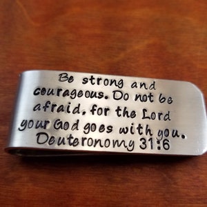 May include: Silver money clip with the text "Be strong and courageous. Do not be afraid, for the Lord your God goes with you. Deuteronomy 31:6"