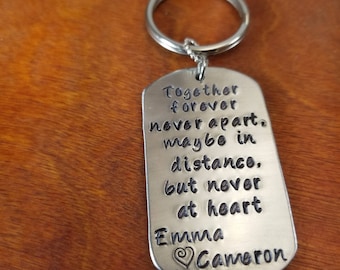 May include: Silver keychain with a dog tag charm that reads "Together forever never apart. Maybe in distance, but never at heart Emma Cameron".