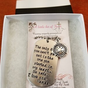May include: A silver necklace with a dog tag pendant that reads "The only fire you can't put out is the one you started in my heart. Be safe. I love you, Renee." The dog tag is attached to a silver chain with a small silver charm that reads "Fire Dept."