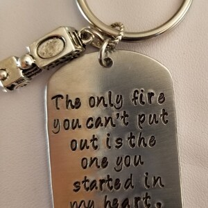 May include: Silver keychain with a small train charm and a tag that reads "The only fire you can't put out is the one you started in my heart. Be safe. I love you, Renee."
