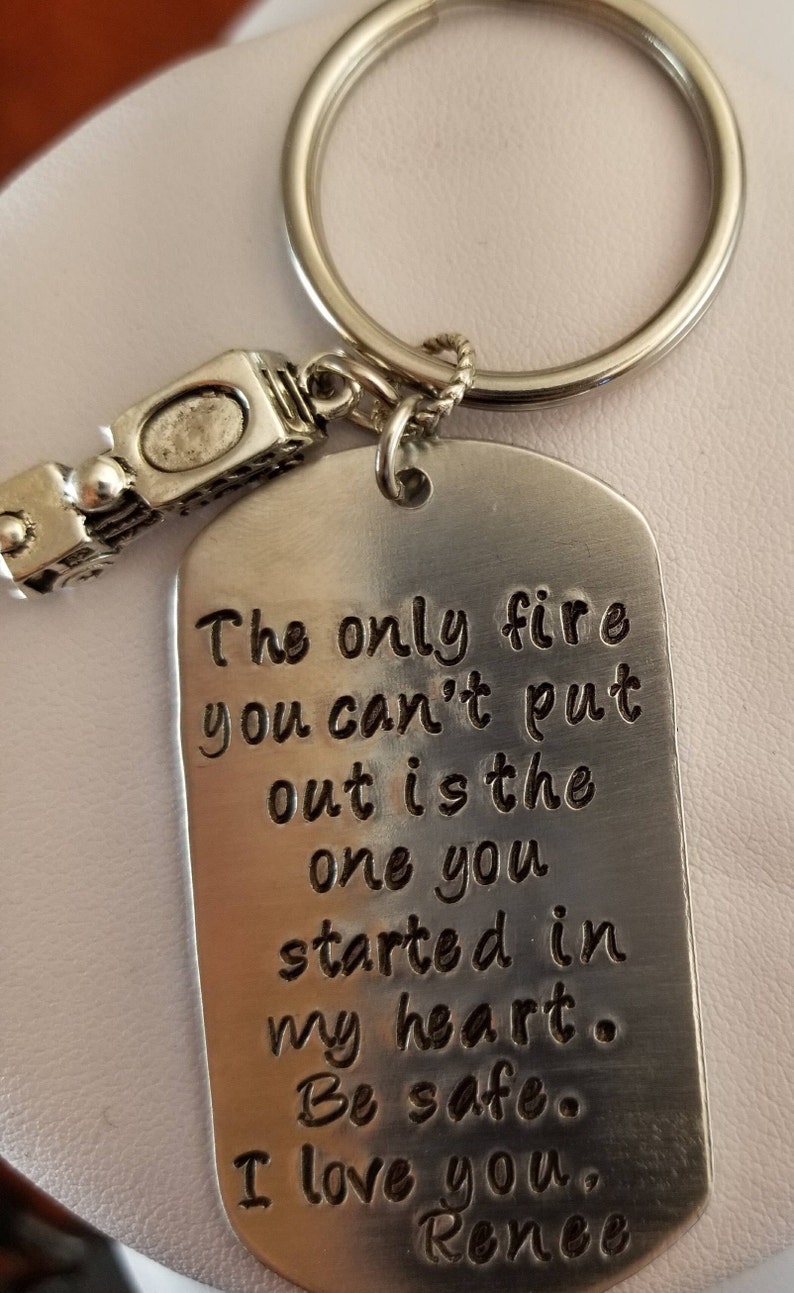 May include: Silver keychain with a small train charm and a tag that reads "The only fire you can't put out is the one you started in my heart. Be safe. I love you, Renee."