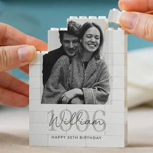 May include: A white building block construction featuring a black and white photograph of a couple. The block displays the name William in script, the number 1996 in a large font, and the text HAPPY 30TH BIRTHDAY printed on the front surface.