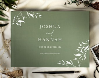 May include: A rectangular sage green guest book featuring white botanical illustrations in the corners. The text reads JOSHUA and HANNAH, OCTOBER 28TH 2026, and SOMERSET HOUSE, YORKSHIRE in white serif and script fonts centered on the front cover.