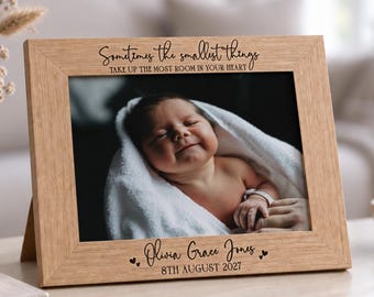 May include: A light brown wooden picture frame featuring the engraved text Sometimes the smallest things take up the most room in your heart at the top and the name Olivia Grace Jones with the date 8th August 2027 at the bottom.