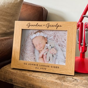 a picture frame with a baby holding a teddy bear