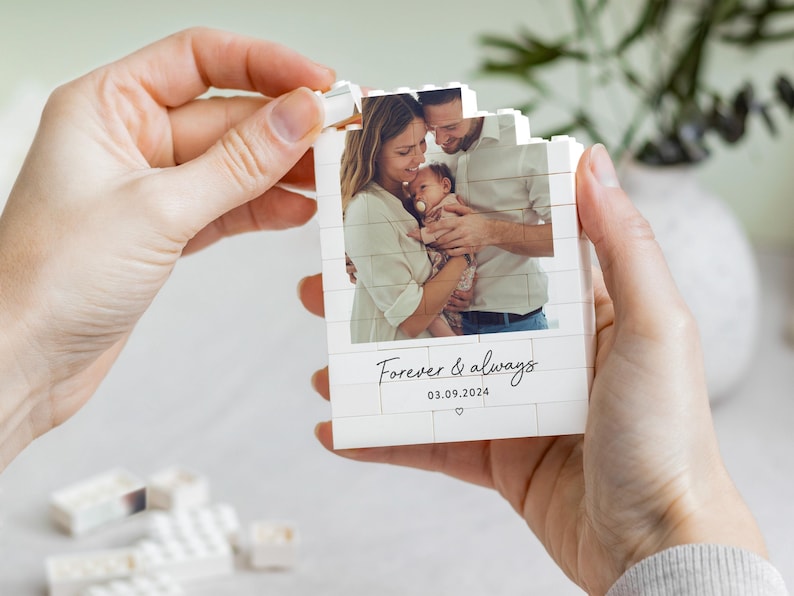 A person's hands holding a small white card with a photograph of a family, and the text "Forever & always" and the date "03.09.2024" printed on it.