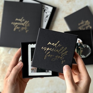 A person's hands holding a black box with gold text that says "made especially for you".