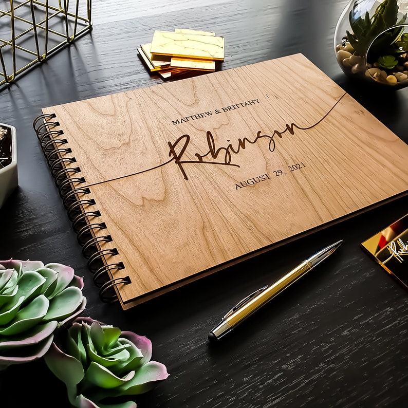 Alternative wedding guest book with this personalized wood engraved guestbook. This rustic wedding décor feature a custom wooden guestbook, and wedding table décor. Wedding sign and confetti, this wedding planner book is from Secret Creation Ltd