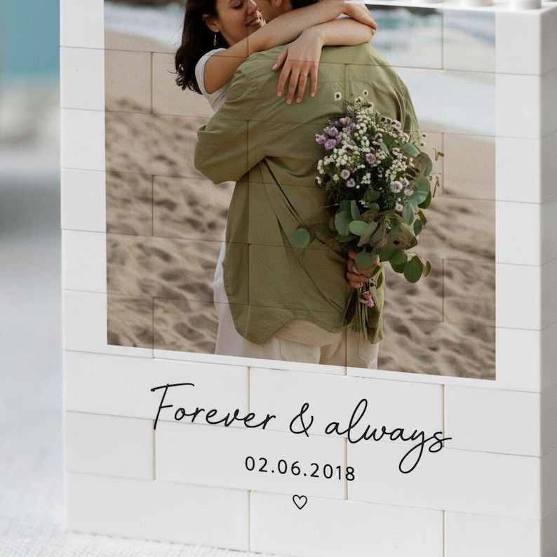 A couple embracing on a beach, with a bouquet of flowers in their hands.