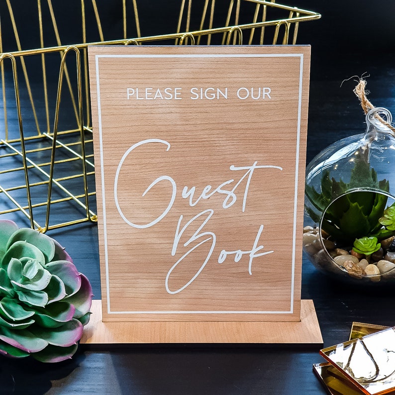 Alternative wedding guest book with this personalized wood engraved guestbook. This rustic wedding décor feature a custom wooden guestbook, and wedding table décor. Wedding sign and confetti, this wedding planner book is from Secret Creation Ltd