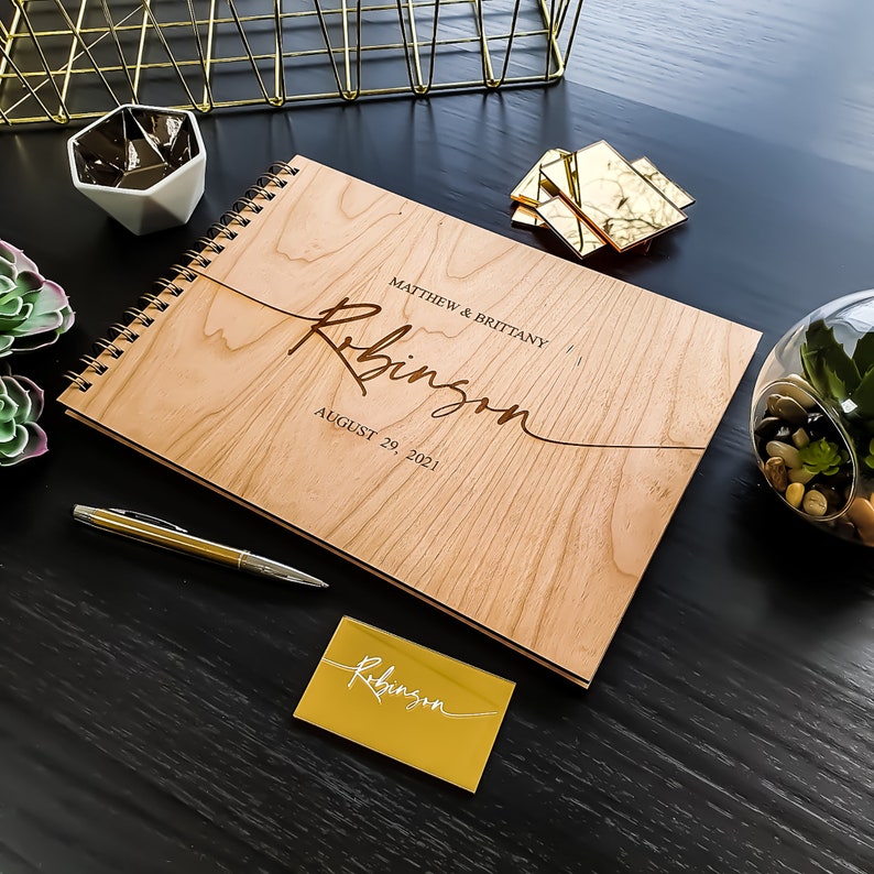 Alternative wedding guest book with this personalized wood engraved guestbook. This rustic wedding décor feature a custom wooden guestbook, and wedding table décor. Wedding sign and confetti, this wedding planner book is from Secret Creation Ltd