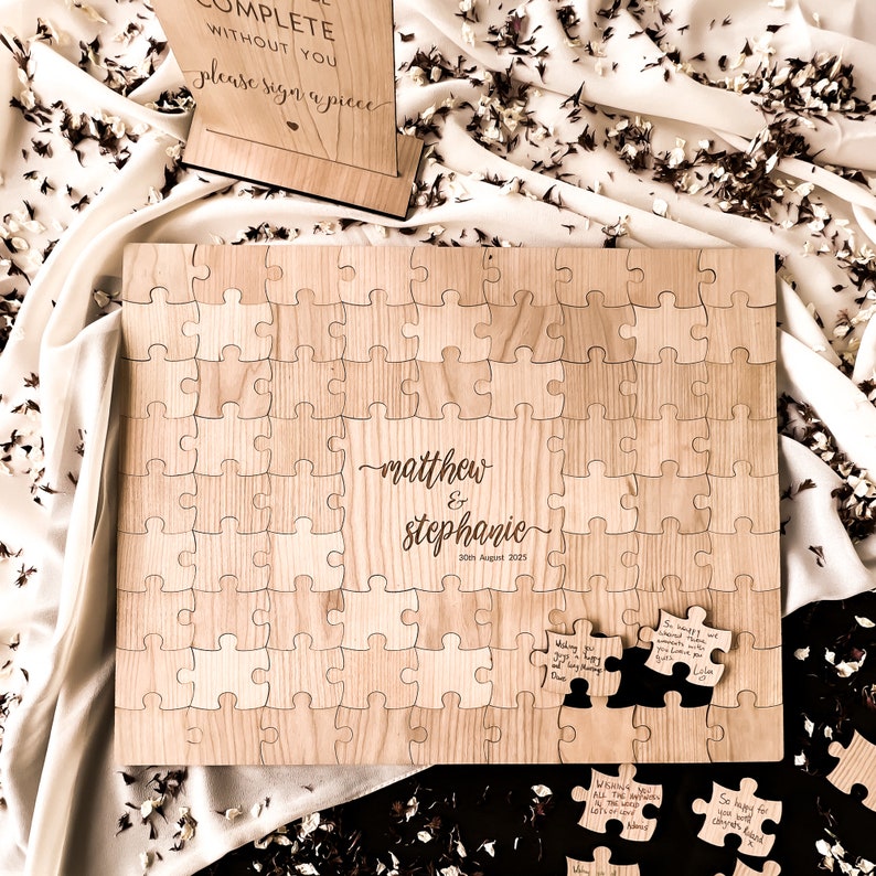 Alternative wedding guest book with this personalised wood puzzle guestbook. This rustic wedding décor feature custom jigsaw pieces, wedding table décor. Wedding sign and dried confetti, this wooden guest book is made by Secret Creation Ltd.