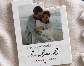 May include: A white rectangular building block display featuring a printed photograph of a couple embracing on a beach. The text reads TO MY WONDERFUL husband HAPPY BIRTHDAY with a small red heart icon printed below the text on the block surface.