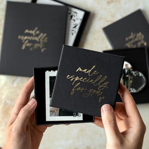 A person's hands holding a black box with gold text that says "made especially for you".
