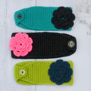 May include: Three crocheted headbands with fabric flowers. The headbands are teal, black, and green. The flowers are black, pink, and navy blue.