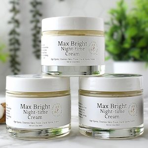 May include: Three clear glass jars with white lids containing Max Bright Night-time Cream. Each label features the text Max Bright Night-time Cream, Age Spots, Uneven Skin Tone, Dark Spots, Scars, and Net wt 2.3oz 68ml in black lettering.