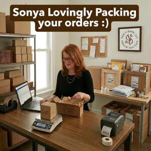 May include: A workspace featuring a person in a black long-sleeve shirt packing orders into a cardboard box. The desk includes a digital scale, a laptop, a label printer, and shipping supplies. Text at the top reads: Sonya Lovingly Packing your orders :)