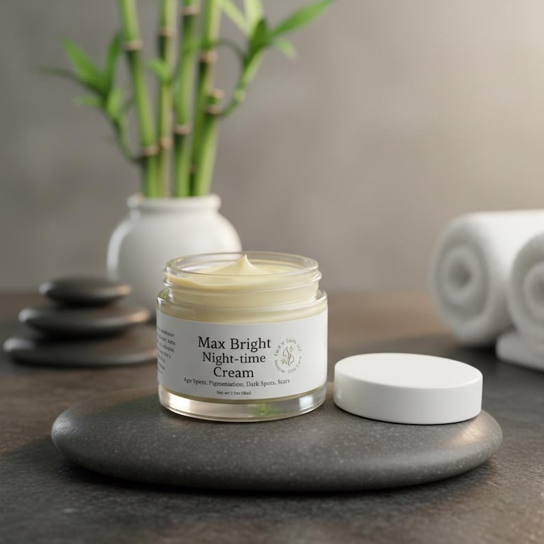 May include: A clear glass jar of Max Bright Night-time Cream with a white lid. The label reads Max Bright Night-time Cream, Age Spots, Pigmentation, Dark Spots, Scars, and Net Wt 2 oz (56g). The cream inside is pale yellow and smooth.