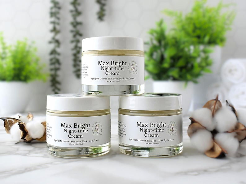 May include: Three clear glass jars with white lids containing Max Bright Night-time Cream. Each label features the text Max Bright Night-time Cream, Age Spots, Uneven Skin Tone, Dark Spots, Scars, and Net wt 2.3oz 68ml in black lettering.