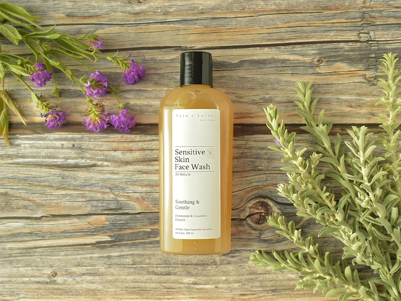 May include: A clear plastic bottle of Face n Earth Skin Care Sensitive Skin Face Wash with a black cap. The white label features the text Sensitive Skin Face Wash, All Natural, Soothing & Gentle, Chamomile & Cucumber Extracts, and 10 fl oz 300 ml.