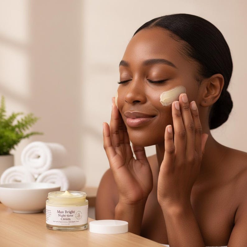 May include: A glass jar of Max Bright Night-time Cream with a white lid, containing a pale yellow facial cream. The label features the text Max Bright Night-time Cream. The jar sits on a wooden surface next to a small white bowl and white towels.