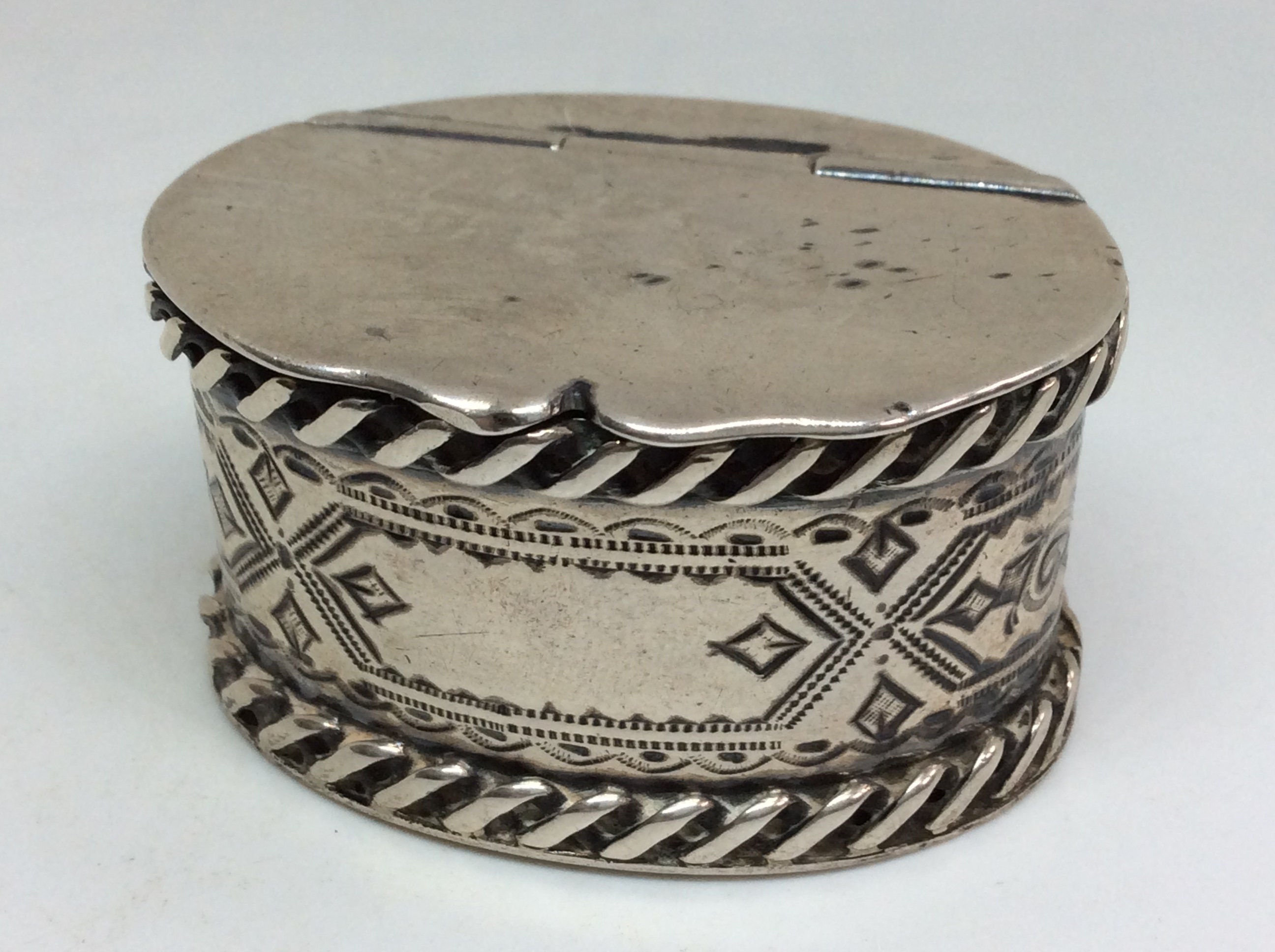 A Silver Pill Box with Embossed Fairy Decoration to Lid