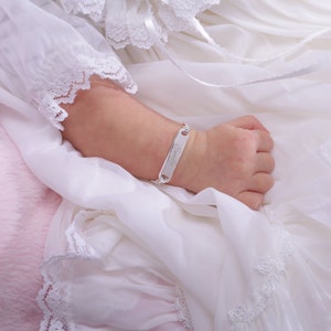 Baby girl wearing sterling silver ID bracelet.