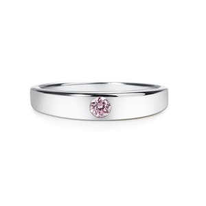 May include: A silver band ring with a single pink gemstone set in the centre.