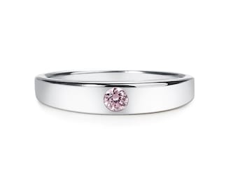 May include: A silver band ring with a single pink gemstone set in the center.