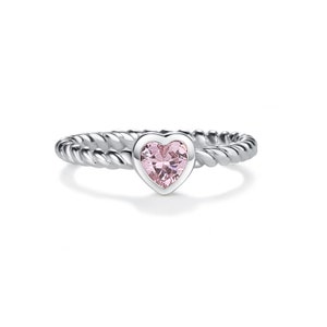May include: A silver ring with a pink heart-shaped gemstone. The band has a twisted rope design. The gemstone is set in a bezel setting, and the ring is displayed on a white background. A piece of jewelry.