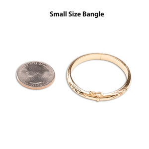 A quarter next to a small size bangle for size reference.