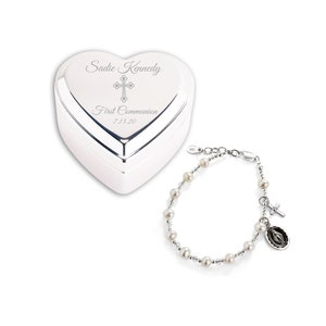 May include: A silver heart-shaped box with the inscription "Sadie Kennedy First Communion 7.13.20" and a silver bracelet with white pearls and a cross charm.