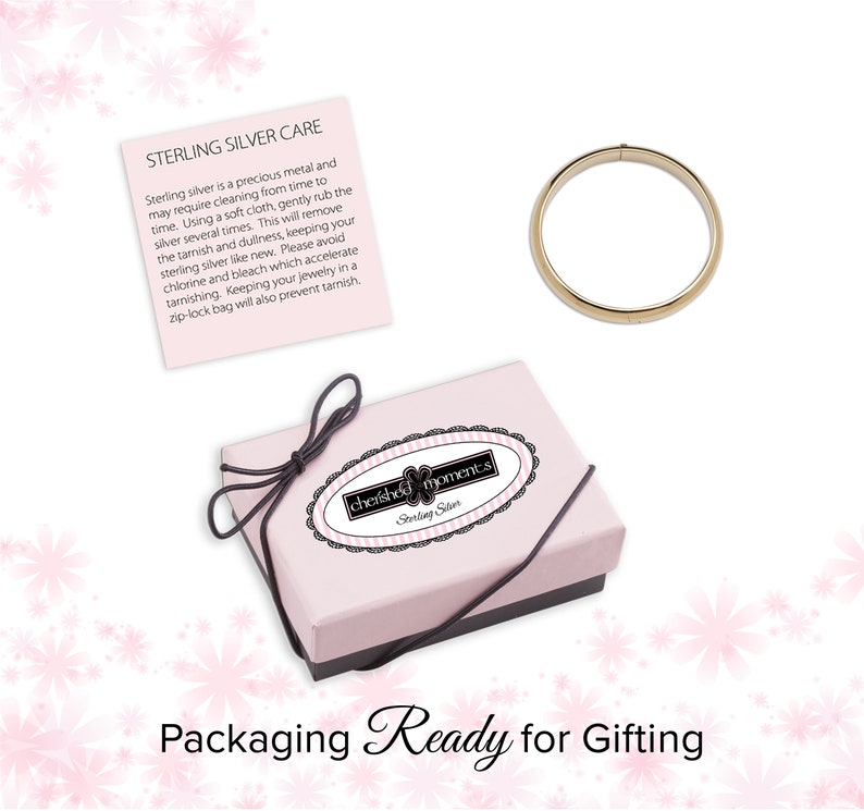 Care information card. 14K gold plated bangle. Pink storage and gift box with black elastic bow ready for gifting.