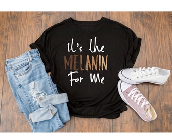 May include: Black t-shirt with the text "It's the MELANIN For Me" in white lettering. The word "MELANIN" is in brown, tan, and light brown shades.