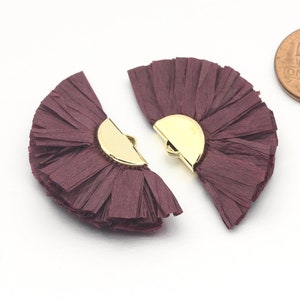 May include: Two burgundy paper fan embellishments with gold metal accents. The fans are approximately the size of a UK penny.