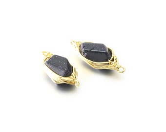 May include: Two gold wire wrapped pendants with dark blue gemstone accents. The wire is wrapped around the gemstone in a decorative pattern.